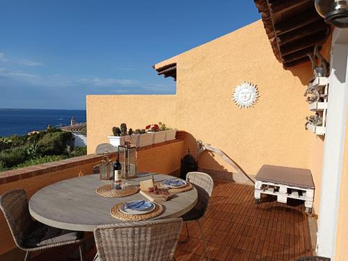 a table and chairs on a balcony with the ocean at Baja Sardinia in Baja Sardinia