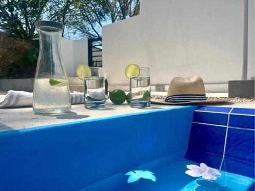 a table with glasses and a vase and a hat at Ecohab el paraíso in Barranca de Upía