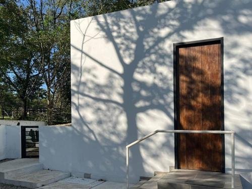 a shadow of a tree on the side of a building at Ecohab el paraíso in Barranca de Upía