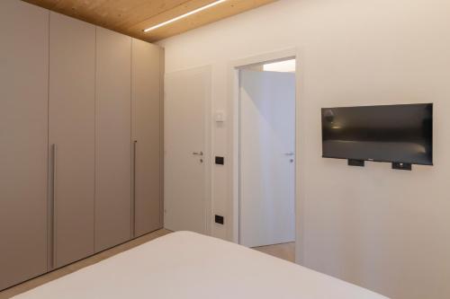 a bedroom with a bed and a tv on a wall at The Nest - TRILO - WIFI - Box - Cortile - Magnolta in Aprica