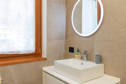 a bathroom with a white sink and a mirror at The Nest - TRILO - WIFI - Box - Cortile - Magnolta in Aprica