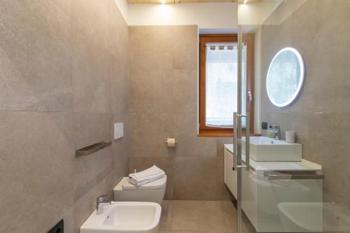 a bathroom with a sink and a toilet and a window at The Nest - TRILO - WIFI - Box - Cortile - Magnolta in Aprica