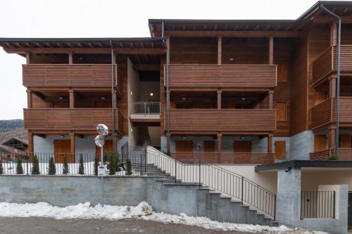 an apartment building with wooden balconies and stairs at The Nest - TRILO - WIFI - Box - Cortile - Magnolta in Aprica