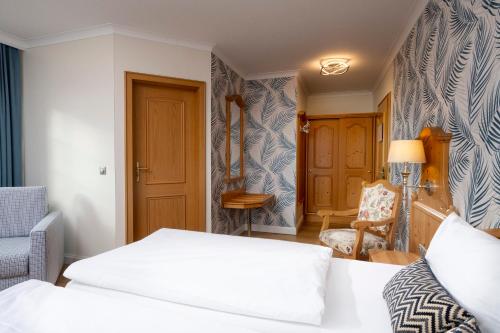a bedroom with two white beds and a chair at Hotel Linther Hof in Linthe