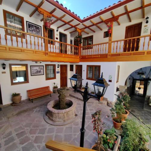 a courtyard with a staircase and a fountain in a building at Hotel Rumi Punku in Cusco