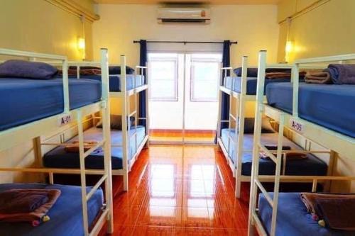 a room with four bunk beds and a door at Chiangmai by DD&B hostel in Chiang Mai