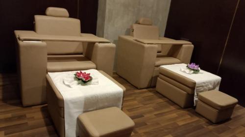 a room with chairs and tables with flowers on them at Hotel Noorjahan Grand in Sylhet