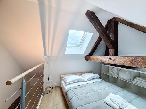 Cette petite chambre mansardée comprend un lit et une fenêtre. dans l'établissement Immeuble idéal groupe - Gare à proximité 19 pers, à Clermont-Ferrand