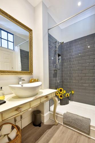 a bathroom with a sink and a mirror at Hampton Court Grand Snug Sleeps 6 - Palace walk in East Molesey