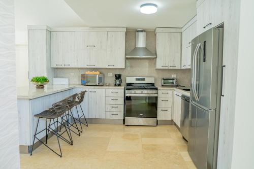 a kitchen with white cabinets and stainless steel appliances at Xeliter Green One Playa Dorada in San Felipe de Puerto Plata