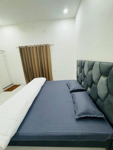 a large bed in a room with a curtain at Aarambh - The Comfort Homestay in Varanasi