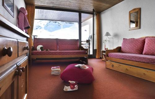 - une chambre avec un canapé, un lit et une fenêtre dans l'établissement Abrineige Le Schuss Val Thorens, à Val Thorens