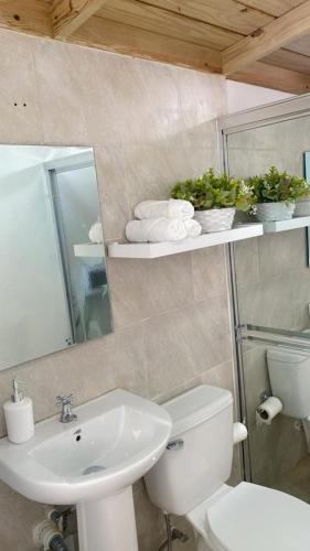 a bathroom with a white toilet and a sink at Caribbean Villa 32 Punta Cana in Punta Cana
