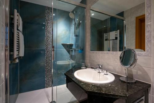a bathroom with a sink and a glass shower at Hotel Linther Hof in Linthe