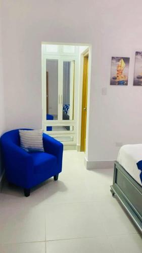 a bedroom with a blue chair and a bed at Caribbean Villa 32 Punta Cana in Punta Cana