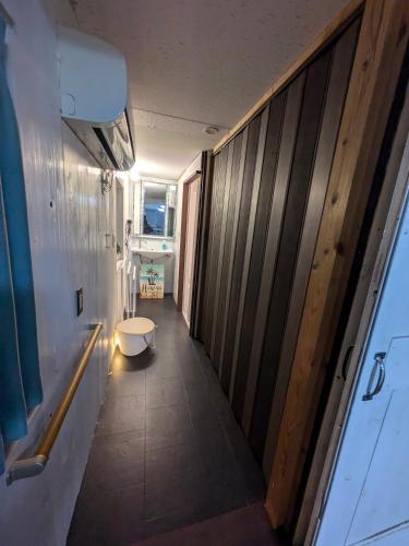 a room with a hallway with a bench and a table at あさひシーサイドコテージ in Asahi