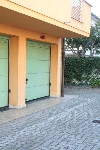 two garage doors on the side of a house at AlMa Apartament in Lucca