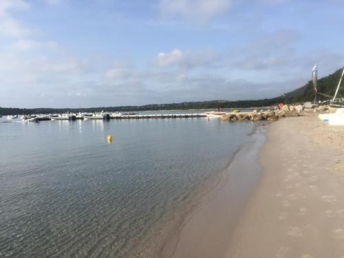 une plage avec un groupe de bateaux dans l'eau dans l'établissement Mini villa a 300m de la plage, à Zonza