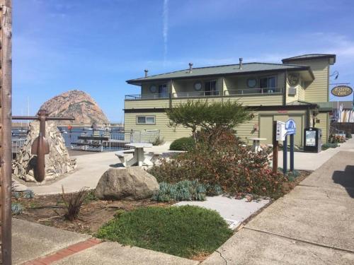 a green building with a bench in front of it at Estero Inn in Morro Bay
