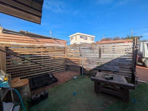 a wooden fence with a table in front of it at あさひシーサイドコテージ in Asahi