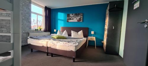 una camera da letto con un letto con una parete blu di Harz Hostel a Wernigerode
