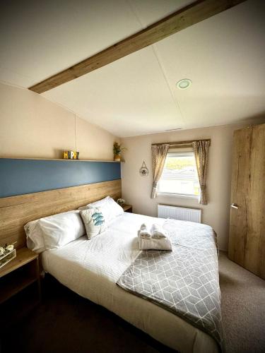 a bedroom with a large bed with a wooden headboard at PV70 newquay bay resort in Newquay Bay Resort