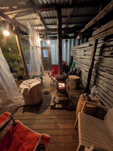 a screened in porch with a fireplace and a stove at あさひシーサイドコテージ in Asahi