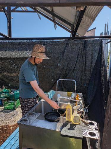 a man is preparing food in a grill at あさひシーサイドコテージ in Asahi