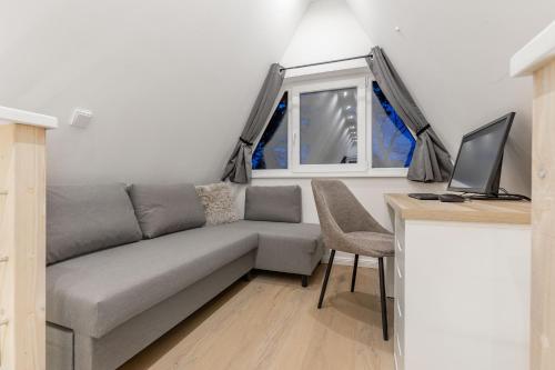a living room with a couch and a desk with a computer at Nurdachhaus Winsen Aller in Winsen Aller