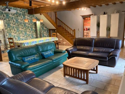 - un salon avec des canapés en cuir et une table dans l'établissement Maison 5 chambres avec jardin à Ganzeville, 265 m², à Ganzeville