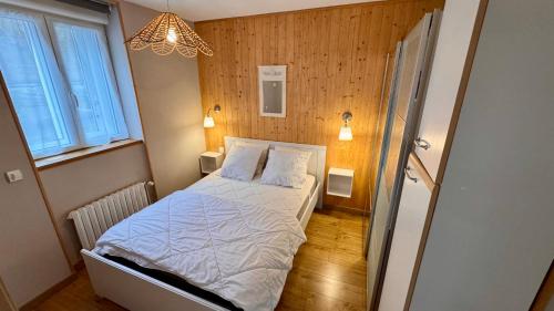 Cette petite chambre comprend un lit avec des draps blancs. dans l'établissement Résidence Les Planchettes, à Le Mont-Dore