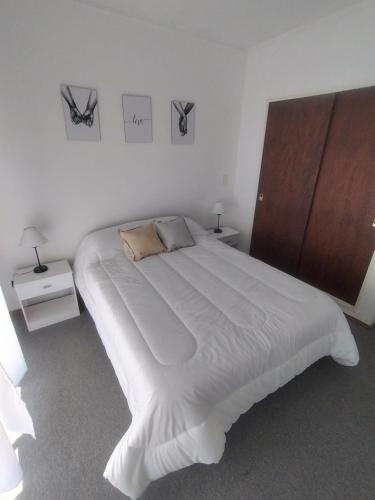 a bedroom with a large white bed with two night stands at Departamento 9 de Julio in Tandil