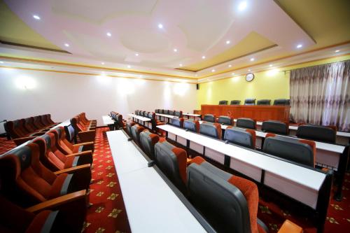 an empty lecture hall with tables and chairs at Hotel Africana in Kampala