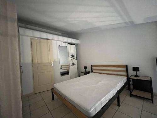 - une chambre avec un lit blanc et une porte dans l'établissement Charmant T2 avec mezzanine au cœur du Village de Canet 2CARLLA16, à Canet