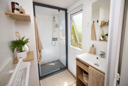 une salle de bain avec douche et lavabo dans l'établissement Camping maeva Escapades Les Trois Sources, à Lamativie