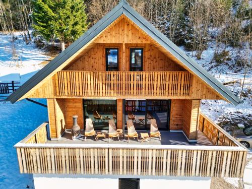 a log home with chairs and a fireplace at Alpine Retreat house Šurc in Rateče