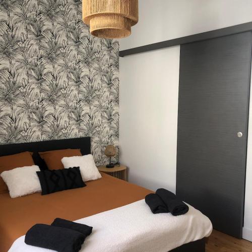 - une chambre avec un lit et des serviettes noires dans l'établissement Charmante maison de ville, à Thouars