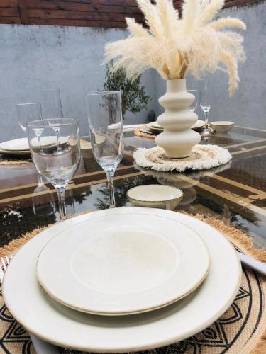 une table avec une plaque blanche et des verres sur celle-ci dans l'établissement Charmante maison de ville, à Thouars