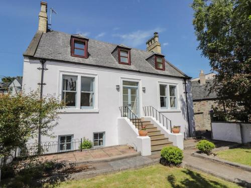 a white house with a staircase in front of it at Mary Ann Villa in Inverness