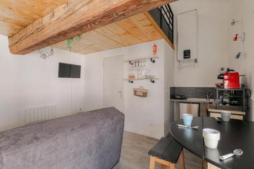 un salon avec une table et une cuisine dans l'établissement Le Mezza, Studio avec Mezzanine, Hypercentre, à Villefranche-sur-Saône