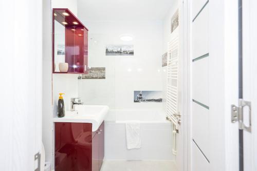 a white bathroom with a sink and a mirror at Apartament Faleza in Galaţi