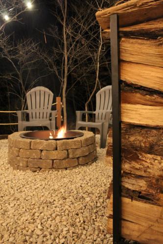 two chairs sitting around a fire pit at night at Modern Getaway - New Outdoor Amenities! - Location in Osage Beach
