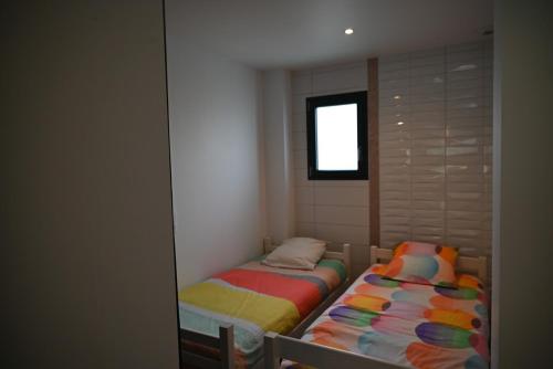 two twin beds in a room with a window at Gîte Gip Enea in Saint-Étienne-de-Baïgorry