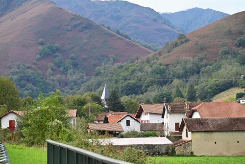 a village with a church and mountains in the background at Gîte Gip Enea in Saint-Étienne-de-Baïgorry