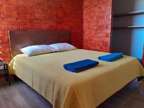 a bed with two blue towels on top of it at Apartamento con vista al lago in Paipa