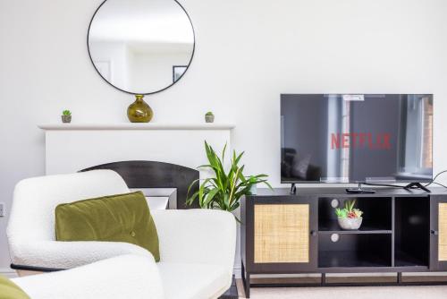 a living room with two chairs and a mirror at PrimeStay Residence in Slough