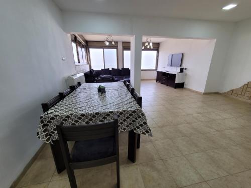 a dining room table with chairs and a living room at Dream in Tiberias in Tiberias