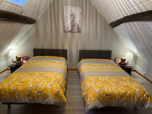 1 Schlafzimmer mit 2 Betten und gelben Decken in der Unterkunft Maison cozy la casa de Coronata Châteaux-Beauval in Gièvres