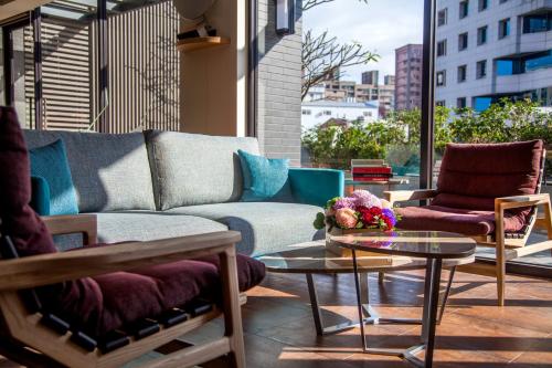 ein Wohnzimmer mit einem Sofa, Stühlen und einem Tisch in der Unterkunft Lacle Hotel-Luzhou Taipei in Taipeh