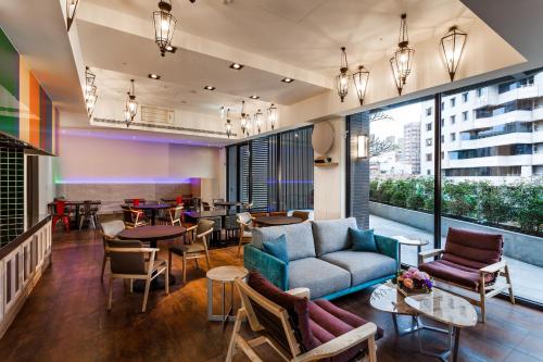 a living room filled with furniture and a large window at Lacle Hotel-Luzhou Taipei in Taipei